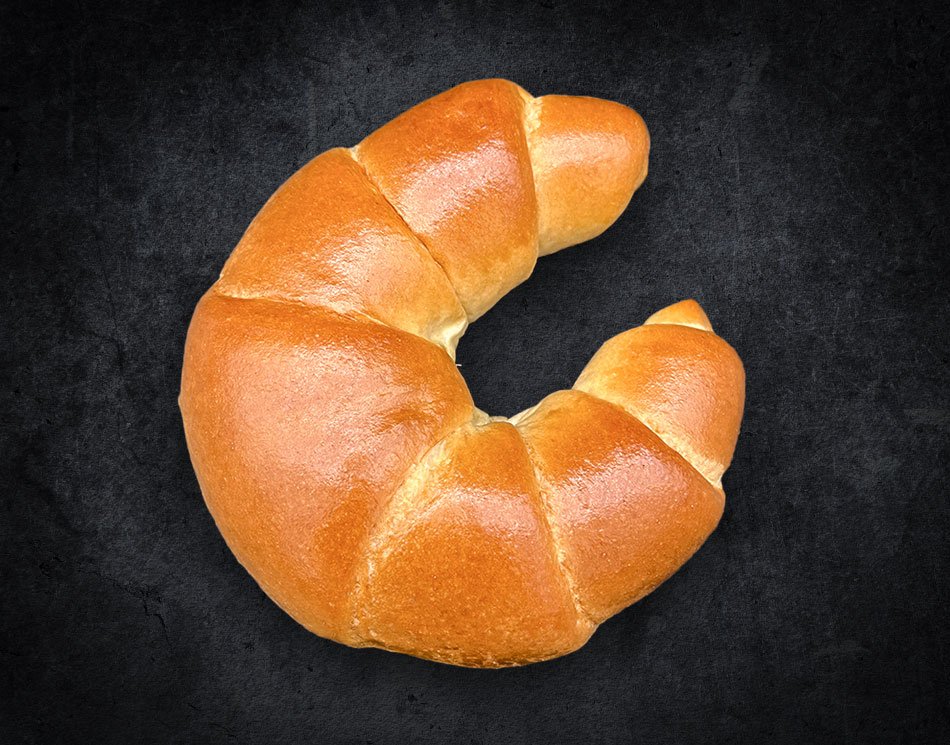 Ein Milch-Hörnchen in C-Form. Es ist goldbraun und gebogen.